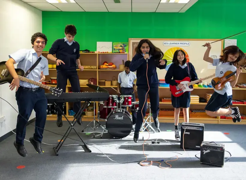 Students playing in a band caught mid jump.
