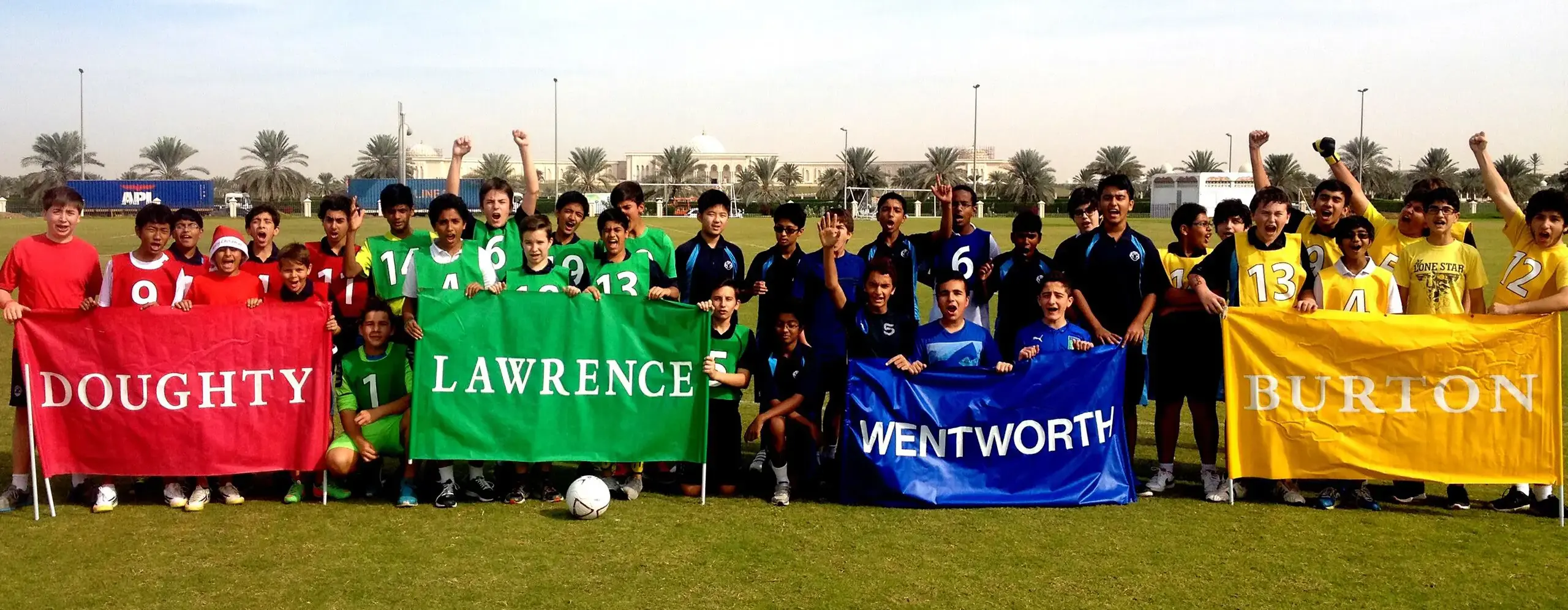 Students with house banners on lawn.